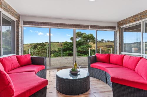 a living room with two red couches and a table at Bulla Hill Villas - Spacious Group Accommodation, 5 Min to Airport in Bulla
