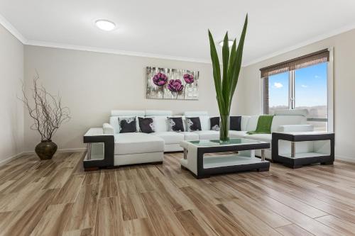 a living room with a white couch and a table at Bulla Hill Villas - Spacious Group Accommodation, 5 Min to Airport in Bulla