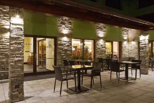 a restaurant with tables and chairs and a green wall at Hotel Hermes in Krnov