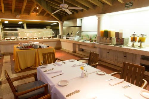 een restaurant met een tafel met witte tafels en stoelen bij Velas Vallarta Suite Resort All-Inclusive in Puerto Vallarta
