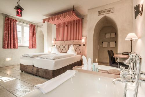 a bedroom with a bed and a bath tub at Hotel Arthus in Aulendorf