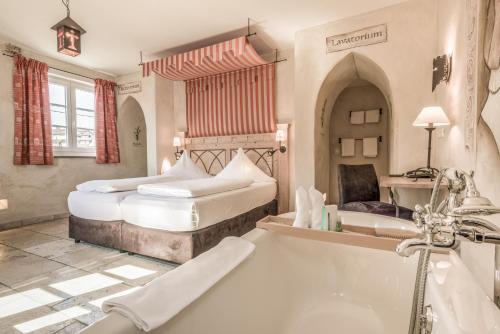a bathroom with two beds and a bath tub at Hotel Arthus in Aulendorf