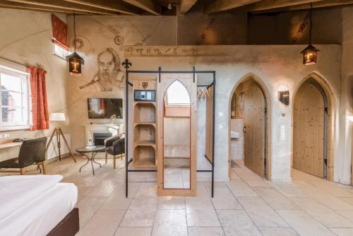 a bedroom with arched doors and a room with a table at Hotel Arthus in Aulendorf