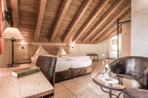 a hotel room with a bed and a table and chairs at Hotel Arthus in Aulendorf