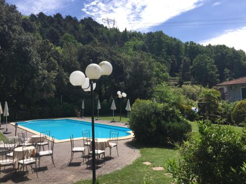 a swimming pool with chairs and umbrellas at Hotel Monti in Lamporecchio