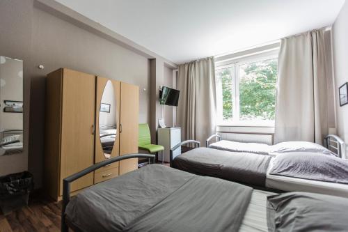 Habitación de hotel con 2 camas y espejo en Bergedorf Haus 9 en Hamburgo