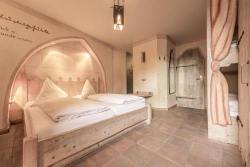 a bedroom with a large bed with an arch above it at Hotel Arthus in Aulendorf