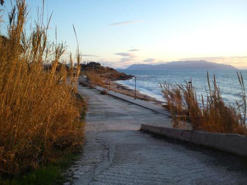 a path next to a beach with the ocean at Voula Apartments in Mitikas