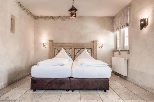 two beds in a room with two white pillows at Hotel Arthus in Aulendorf