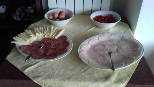 a table with plates of food and bowls of fruit at Hotel Corte Santa Libera in San Fedele Intelvi
