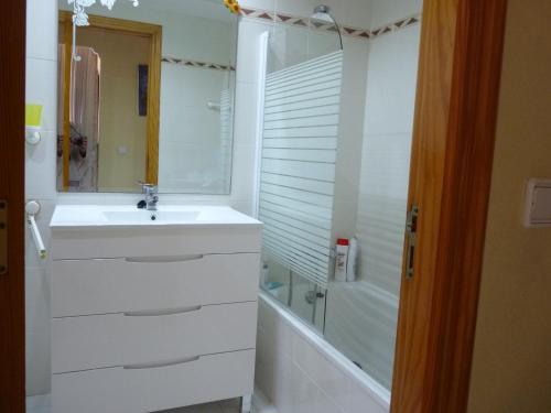 a white bathroom with a sink and a tub at Apartamento En Daimus Con Vistas Al Mar in Daimuz