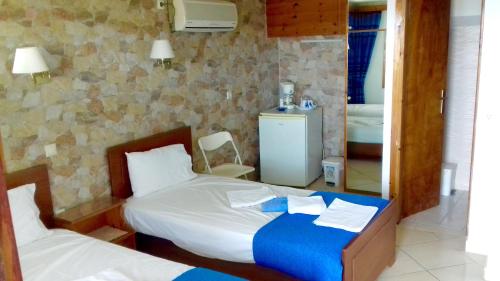um quarto com 2 camas e um espelho em Kostis Rooms em Korissia