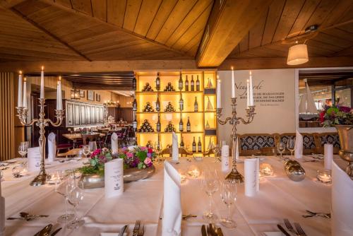 a long table in a room with wine bottles at Hotel Arthus in Aulendorf