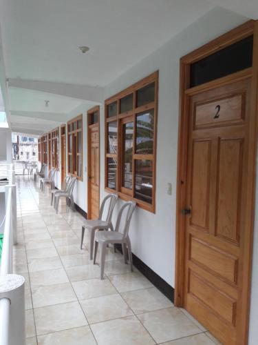 a corridor with chairs and a wooden door at Hotel Xetawaa´l in San Pedro La Laguna