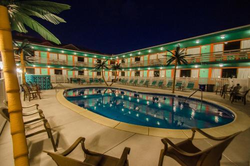 a hotel with a swimming pool at night at Dolphin Inn in Wildwood