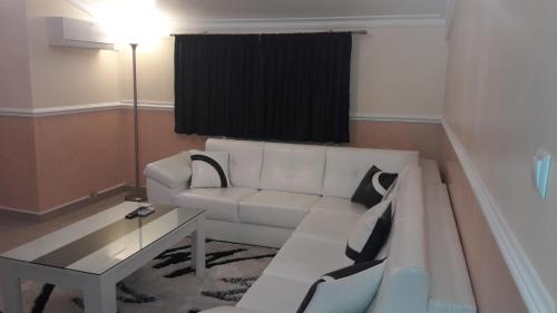 a living room with a white couch and a table at Apartments Royal Menex in Požarevac