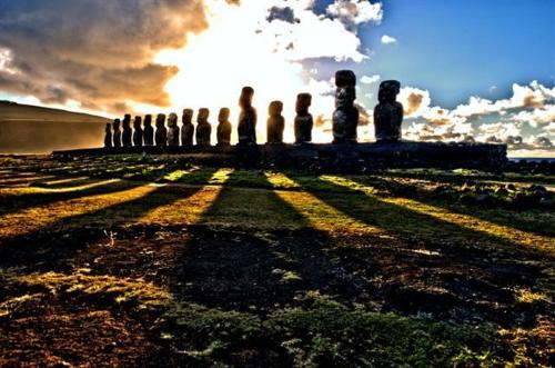 a group of statues sitting on top of a field at Chez Jérôme in Hanga Roa