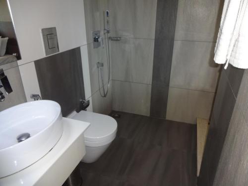 a bathroom with a sink and a toilet and a shower at Paramount Tower in Kozhikode