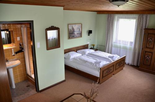 a bedroom with a bed and a sink and a mirror at Locus Malontina Hotel in Gmünd in Kärnten