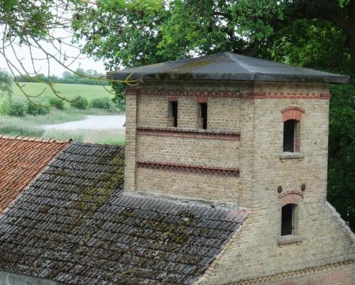 a brick building with windows on top of a roof at Event- Kultur & B&B Kunst Schloss Neuenhagen Übernachten im Denkmal in Bad Freienwalde