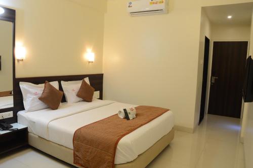 a hotel room with a bed in a room at Hotel GreenLand-Elegant in Kolhapur