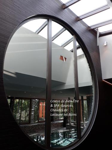 a round window in a building with a sign in it at Logis Le Relais de Fusies in Lacaune