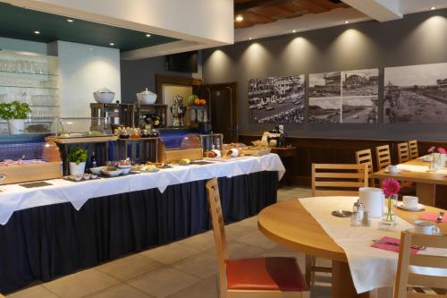 a dining room with tables with white table cloths at Hotel & Restaurant Hüllen in Barweiler