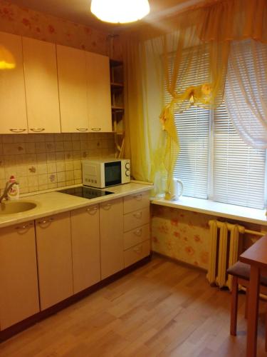 モスクワにあるУно Эстейт ищите в поисковикеの白いキャビネット、電子レンジ、窓付きのキッチン