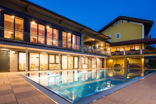 a large house with a swimming pool in front of it at Gasthof Hotel Schmied in Arnfels