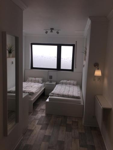 two beds in a room with a window at Pension Lindenhof in Limburg an der Lahn