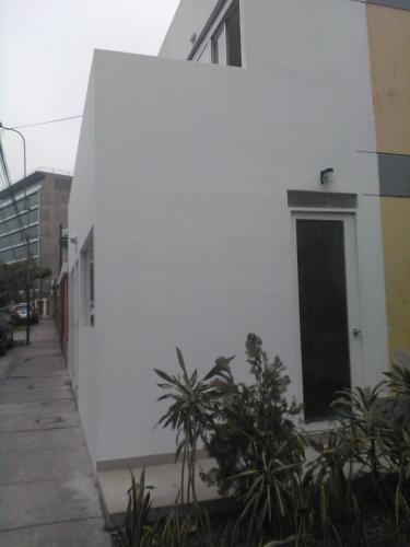 a white building with a door on the side of it at Monterrico Suites Hotel in Lima