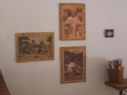 a wall with four pictures on it at Hostal Palohe Taganga in Taganga