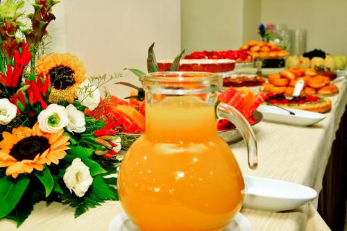 a jug of orange juice on a table with flowers at Hotel Perusia in Perugia