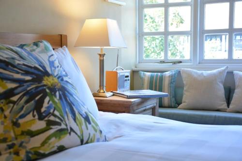 a bedroom with a bed and a couch and a lamp at The Dolphin Inn in Thorpeness