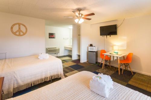 um quarto de hotel com duas camas e uma mesa e uma televisão em Sunset Motel em Murphy