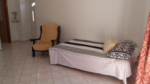 a bedroom with a bed and a yellow chair at Apartman Lana in Banjole