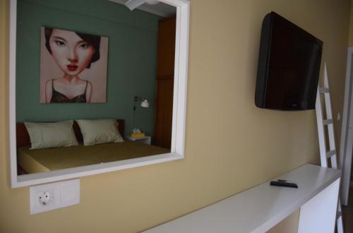 een spiegel aan de muur van een kamer met een bed bij Anestis Home in Thessaloniki