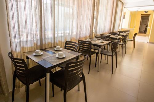 a row of tables and chairs in a restaurant at Hotel Equinocios Essential in Barcarena