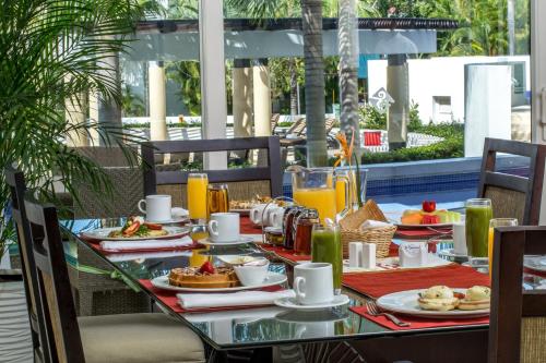 a table with breakfast food and drinks on a patio at Marival Distinct All-Suites & World Spa - Handwritten Collection in Nuevo Vallarta 