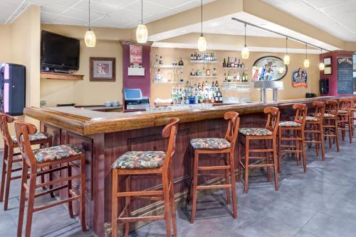 a bar with a row of wooden bar stools at Chester Hotel and Conference Center in Exton