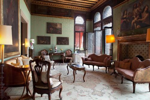 a living room with chairs and a fireplace at Palazzetto Pisani Grand Canal in Venice