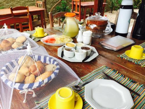 einen Tisch mit Teller mit Speisen darüber in der Unterkunft Pousada Brisa Del Mar in Icaraí
