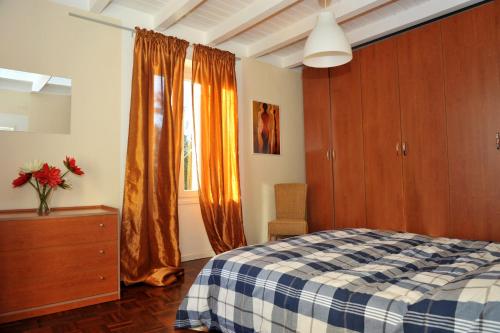 ein Schlafzimmer mit einem Bett, einer Kommode und einem Fenster in der Unterkunft Appartamento del Sole in Maccagno Superiore