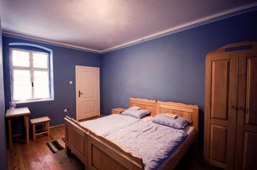 a blue bedroom with a bed and a window at Ethno&Coffee House Tulip in Gložan