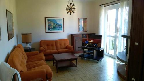 sala de estar con sofá y TV en Casa Mariarosa, en Maccagno Inferiore