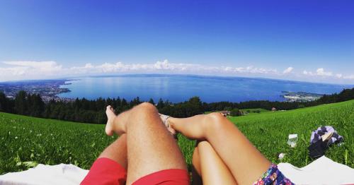 a woman laying on a grassy hill with her legs crossed at Ferienhaus Alpenpanorama Chalet in Mollenberg