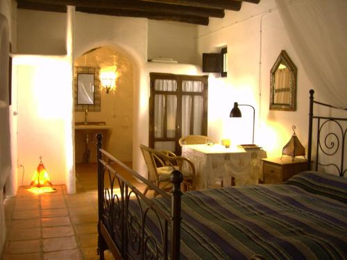 a bedroom with a bed and a table in a room at Hotel Rural Cortijo La Alberca in Níjar