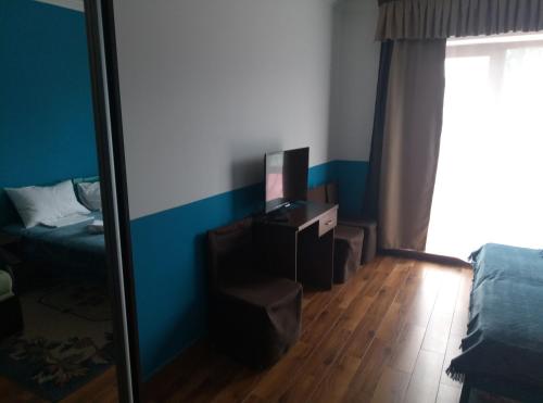 a room with a tv and a chair and a mirror at Dom Fedorovyh in Sergeyevka