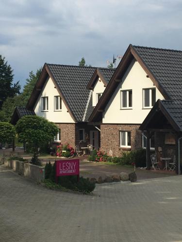 a large house with a sign in front of it at Lesny Apartament in Ostrzyce