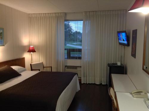 a hotel room with a bed and a window at Shakespeare Inn in Shakespeare